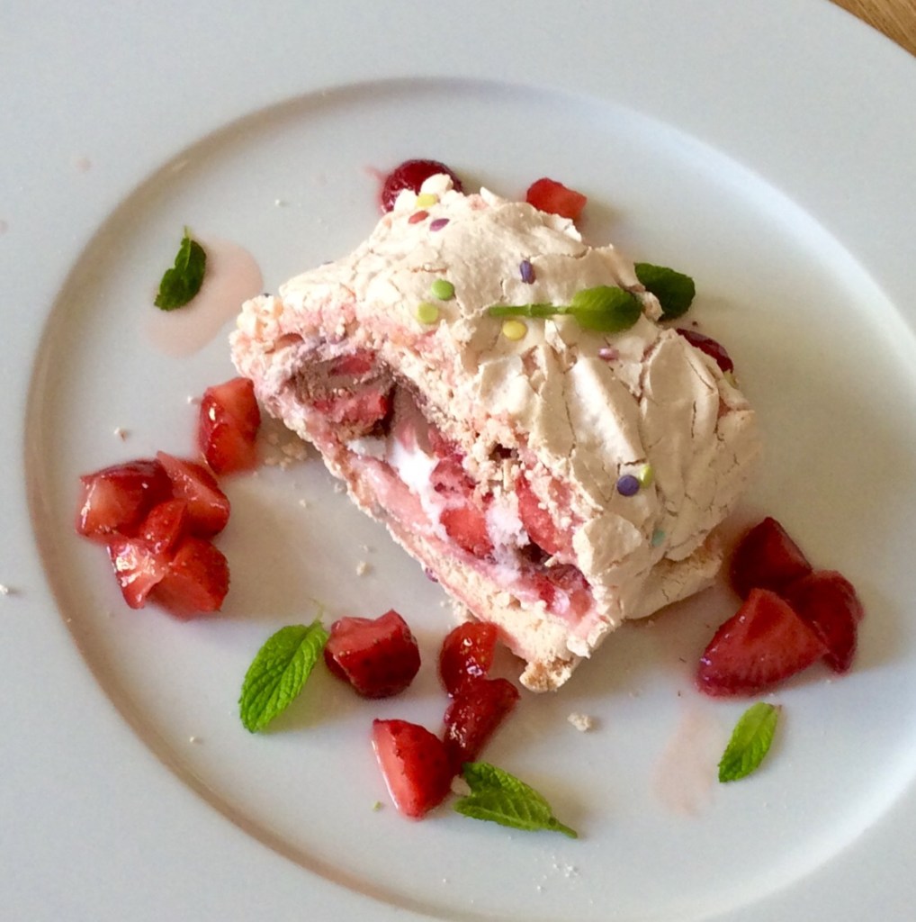 Meringue roulade, strawberries, white plate
