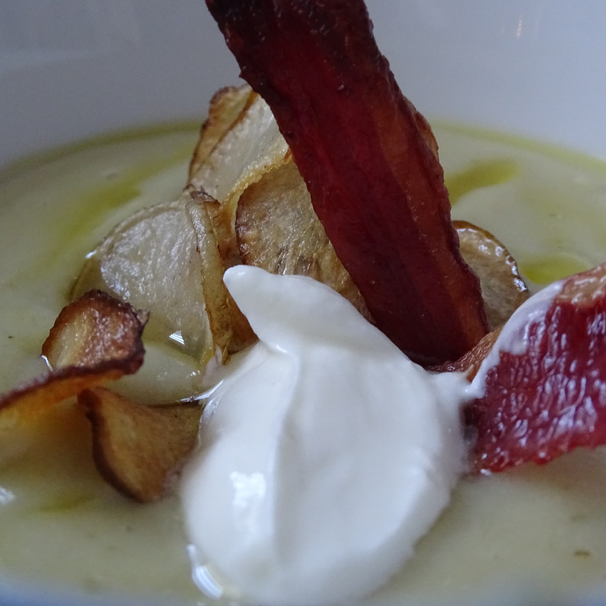 close up of artichoke soup, crispy bacon, greek yogurt