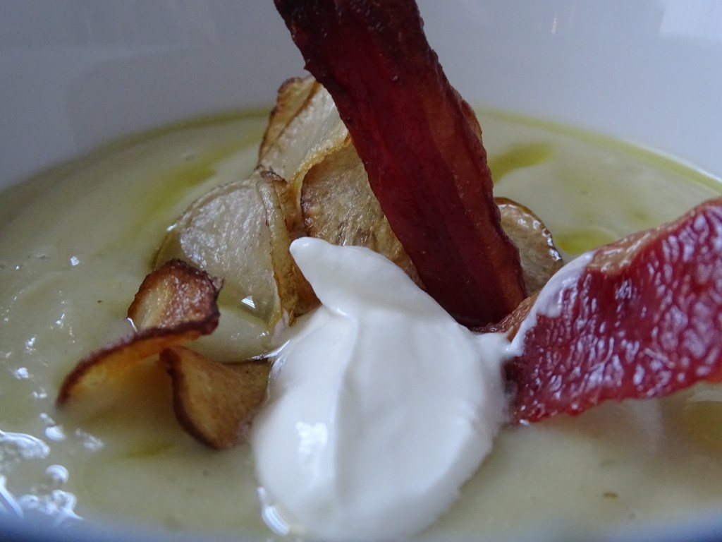 close up of artichoke soup, crispy bacon, greek yogurt