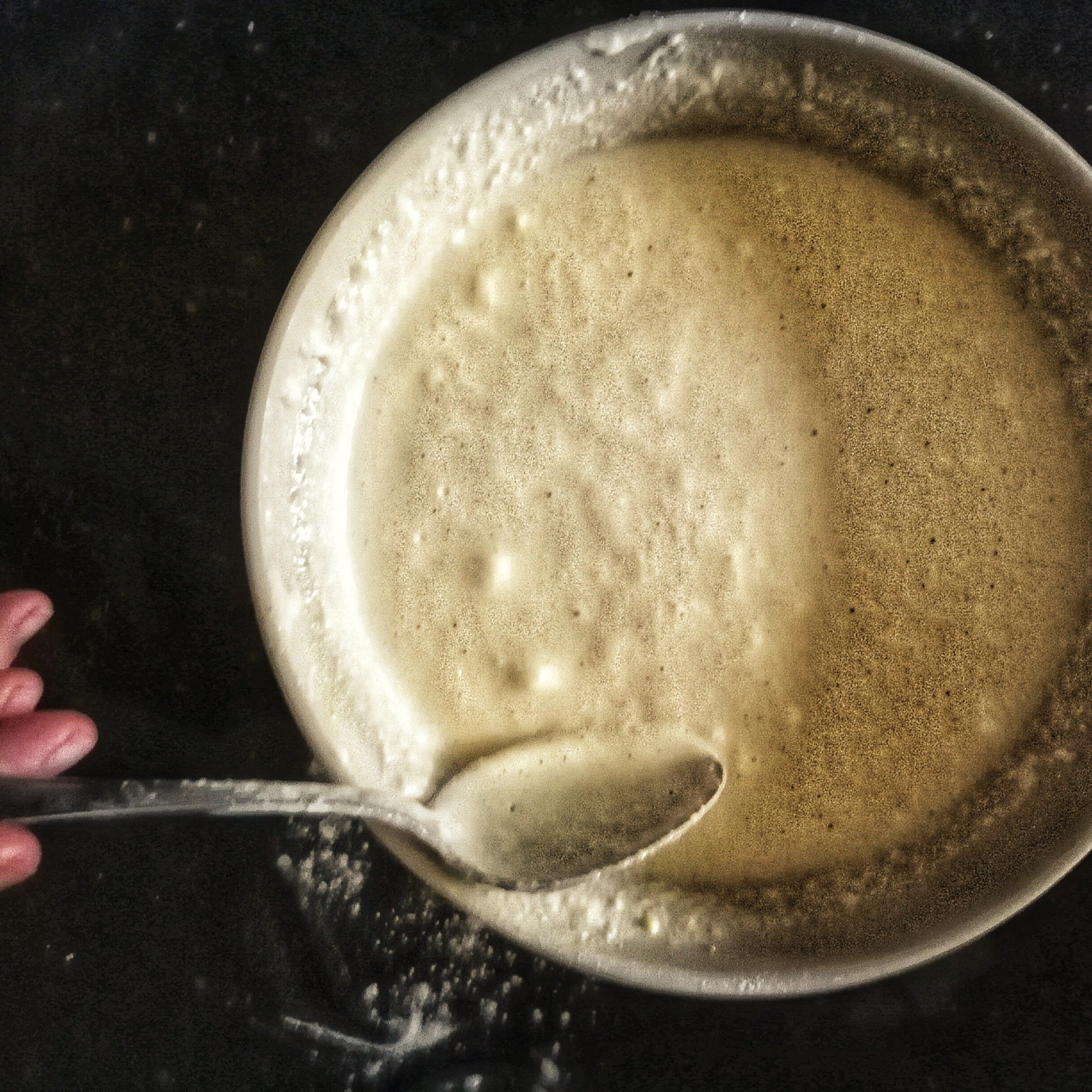 Bowl of waffle batter, spoon, hand