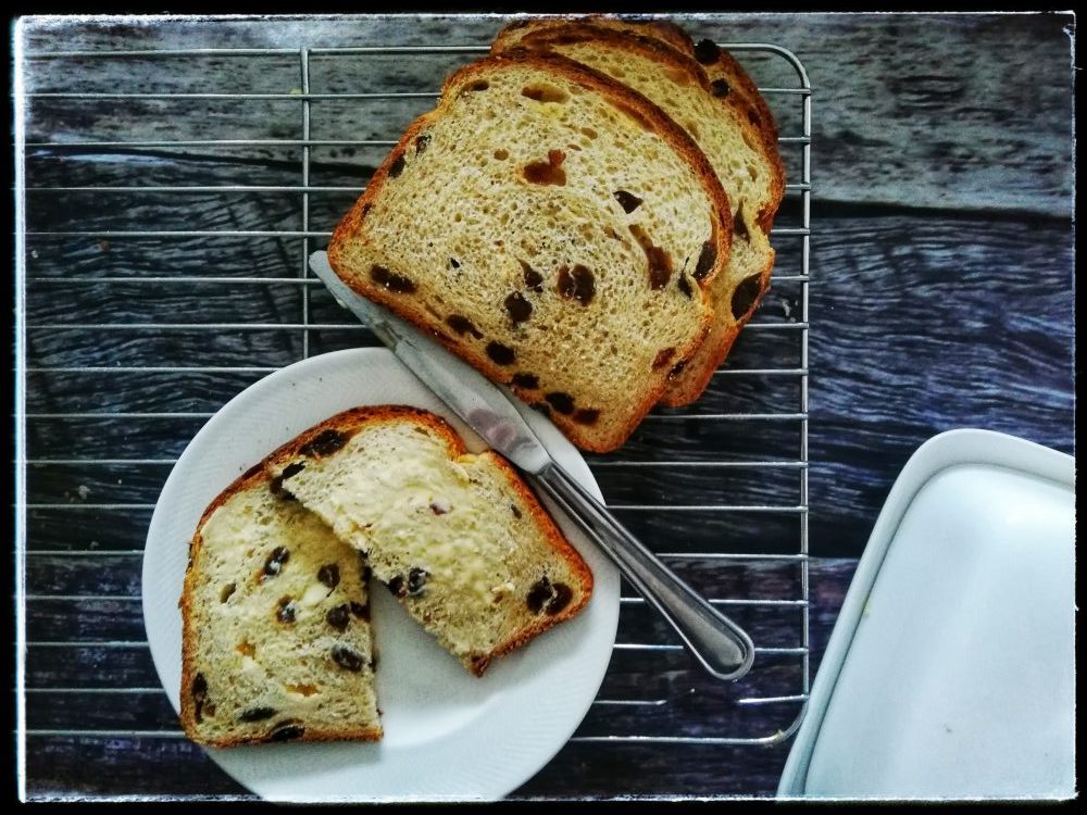 Raisin bread with butter, knife, butter dish