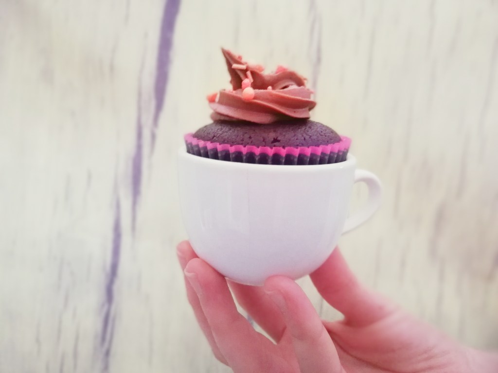 Chocolate caramel cupcake, in Expresso cup, hand holding