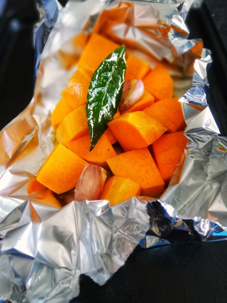 Roasting garlic and butternut squash for dressing, in tin foil.