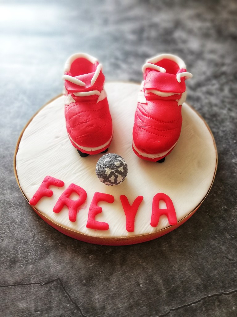 Food photography, Small sugar icing football boots, with name Freya