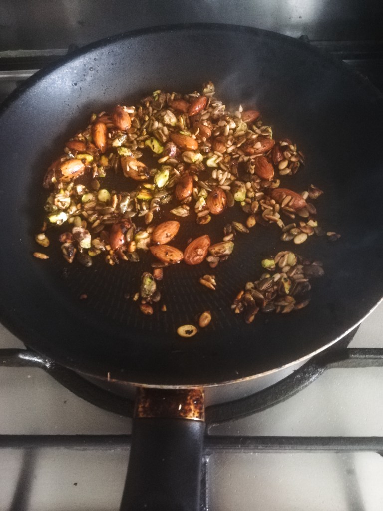Image, Toasted seeds and nuts drizzled with maple syrup to in frying pan