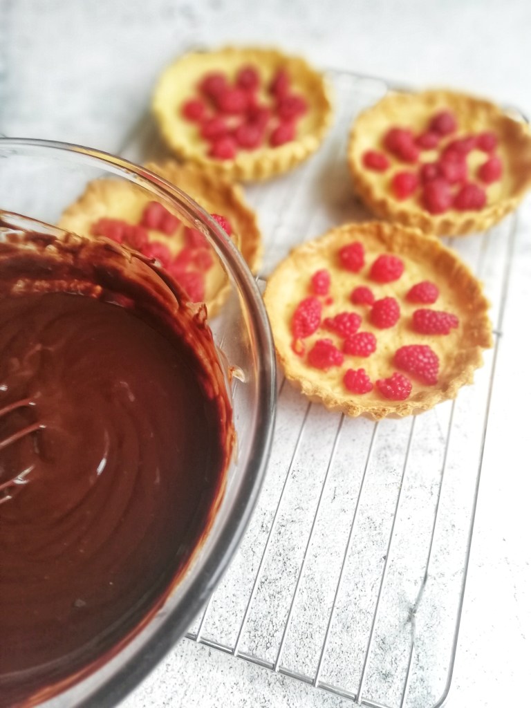 Image,Tart shells, with raspberries, bowl of chocolate ganache.